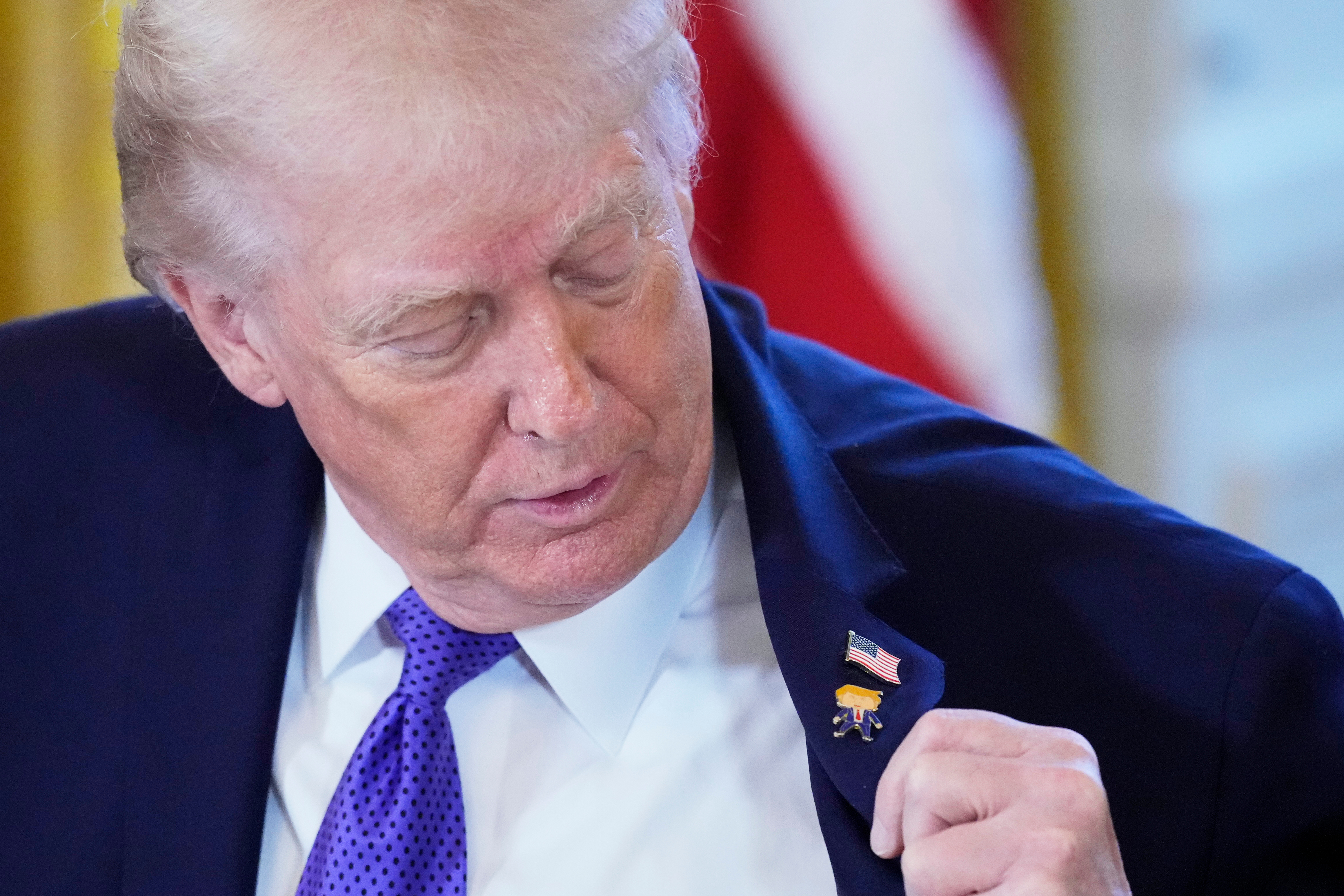 Trump wears a new 'Happy Trump' lapel pin, but insists he's never happy